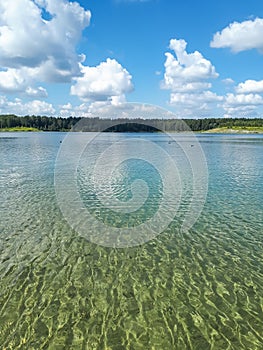 Landscape of lake and forest in the far and texture of crystal clear light Blue, green and turquoise transparent water with fine