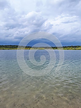 Landscape of lake and forest in the far and texture of crystal clear light Blue, green and turquoise transparent water with fine