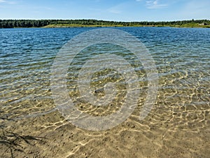 Landscape of lake and forest in the far and texture of crystal clear light Blue, green and turquoise transparent water with fine