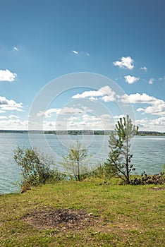 Landscape by the lake in the forest with a wooden table/Lake in the forest with a picnic table. On a sunny day
