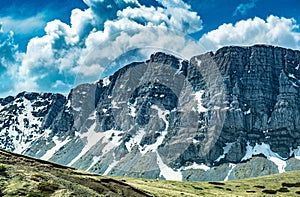 Landscape with lake high in mountains with partial snow