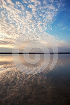 Landscape with lake reflection clouds. Beautiful summer sunset