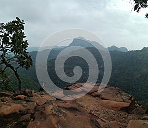 Landscape of layers of mountains and rocks in front.