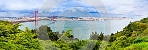 Landscape of Lisbon, Portugal skyline and the 25th of April bridge over the Tagus river estuary as seen from the hills of Almada