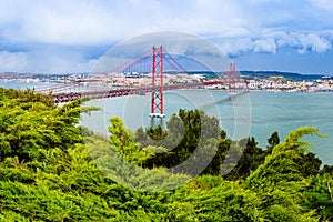 Landscape of Lisbon, Portugal skyline and the 25th of April bridge over the Tagus river estuary as seen from the hills of Almada