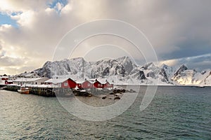 Landscape of the Lofoten Islands in Norway with traditional wooden red fisherman huts in front of the sea and this beautiful mouta