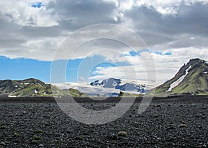 Landscape of Maelifellsandur volcanic black sand desert with Myrdalsjokull glacier and blue sky, summer in Highlands of Iceland