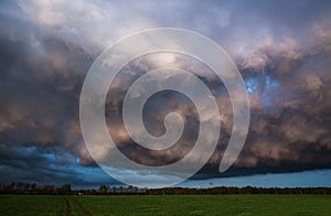 Landscape with majestic colorful dramatic red sky with fluffy clouds at sunset before before a thunderstorm and rain