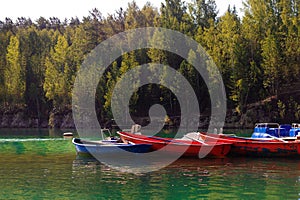 landscape with marble lake, pier with old wooden fishing boat boats