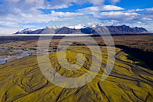 Landscape of the Markarfljot river in a field covered in greenery in Iceland