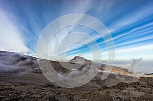 Landscape of the Mawenzi peak of Mount Kilimanjaro under sunlight with cloudscape above