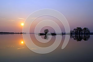 Landscape with mirror reflection in the Bay on the river at sunset