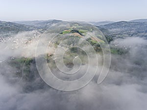 Landscape misty panorama. Fantastic dreamy sunrise on rocky mountains with view into misty valley below. Foggy clouds above