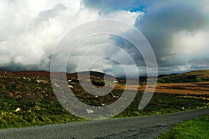 Landscape of moorland in Snowdonia, north Wales.  Heather and gorse fields set against a dramatic sky.