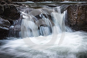 Landscape of mountain river in sunshine. View of the stony rapids.