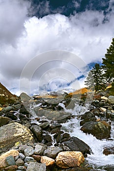 Landscape with mountain river. The water runs in cascades over t