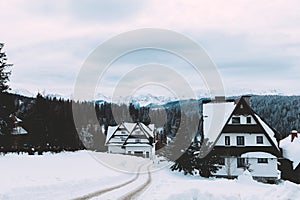 Landscape of mountain village around forest. Snow, clouds. Winter time. Slovakia