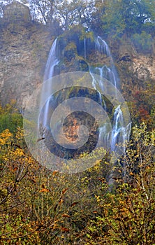 Landscape with mountain waterfall and colorful autumn forest