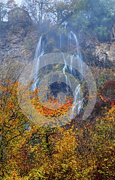 Landscape with mountain waterfall and colorful autumn forest