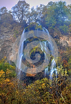 Landscape with mountain waterfall and colorful autumn forest