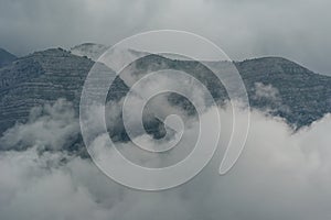 Landscape with mountains and clouds in gray colors.