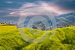 Landscape with mountains and clouds. Green foreground.