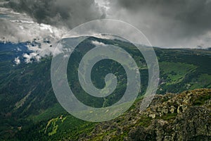 Landscape of mountains covered with green forest during a cloud