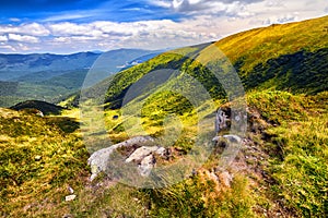 Landscape mountains and green fresh grass under blue sky