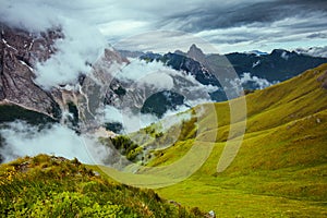 landscape with mountains, hills, clouds, grass and fog