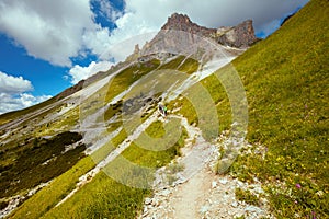 landscape with mountains, hills, clouds, grass and trail