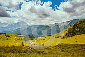 landscape with mountains, hills, clouds, meadow and trees