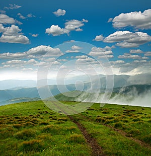 Landscape of mountains on the horizon, under white clouds