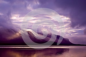 Landscape. Mountains and lake in mist in morning with purple col