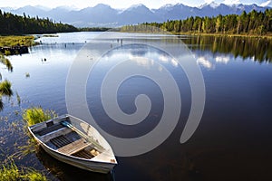 Landscape with mountains, lake and  wooden boat