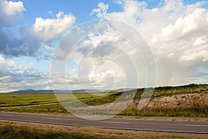 Landscape of mountains, path and plains with clouds photo