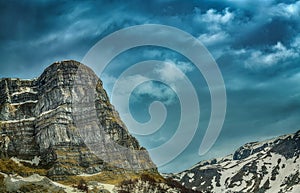 Landscape with the mountains in snow and heavy clouds in the background