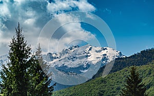 Landscape with the mountains in snow and heavy clouds in the background