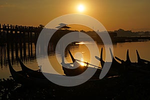 Landscape - nature scene of Silhouette  longest wooden bridge and traditional boat on the lake at u bein bridge with sunrise. This