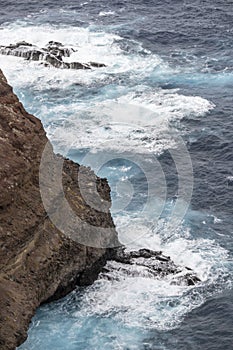 Ocean waves dashing on volcanic cliffs at Ponta do Rosto, Madeira photo