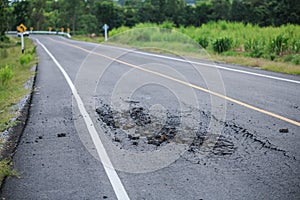 Landscape with an old cracked asphalt road