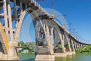 Landscape with an old Merefo-Hersonsky arched bridge over Dnipro river