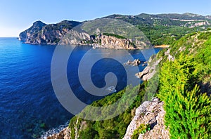 Landscape of Paleokastritsa famous beach in close bay with crystal clear azure water on Corfu island, Ionian archipelago, Greece.