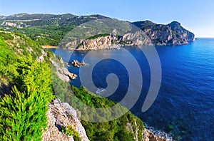 Landscape of Paleokastritsa famous beach in close bay with crystal clear azure water on Corfu island, Ionian archipelago, Greece.