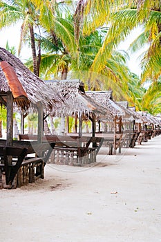 Landscape of paradise tropical island with palms cottages and white sand beach
