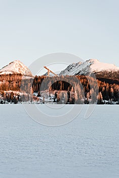 Landscape photo of frozen and snow covered Strba tarn Strbske pleso in winter time. Mountains in Slovakia with frozen lake on