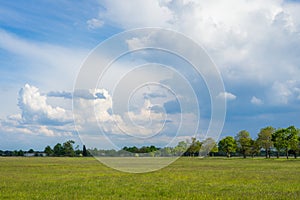 Landscape photo of a green field with cloudy sky
