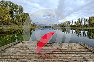 LAndscape photo of a red umbrella on a dock