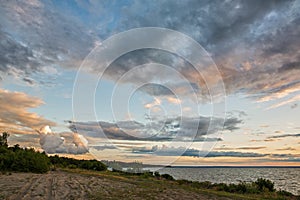 Landscape photo of the sea with the road against the background of the sunset sky