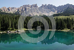 View of the mirror surface of Lake Carezza and the Latemar mountain massif in the Dolomites, taly photo