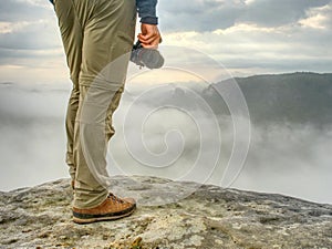 Landscape photograper with camera ready in hand. Man climbed up photo